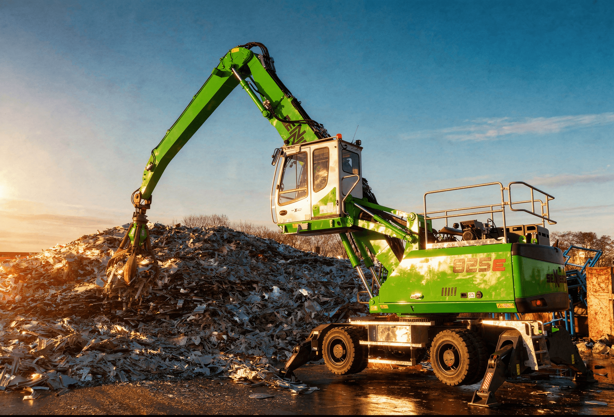 SENNEBOGEN 825E material handler loading scrap at golden hour